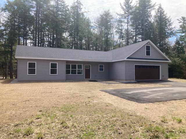ranch-style home with aphalt driveway and an attached garage