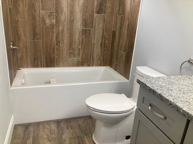 bathroom with vanity, toilet, tub / shower combination, and wood finished floors