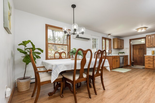 784 Ocean Ave, Portland, ME 04103 - dining space with light wood-style floors, a chandelier, a wall mounted AC, and baseboards