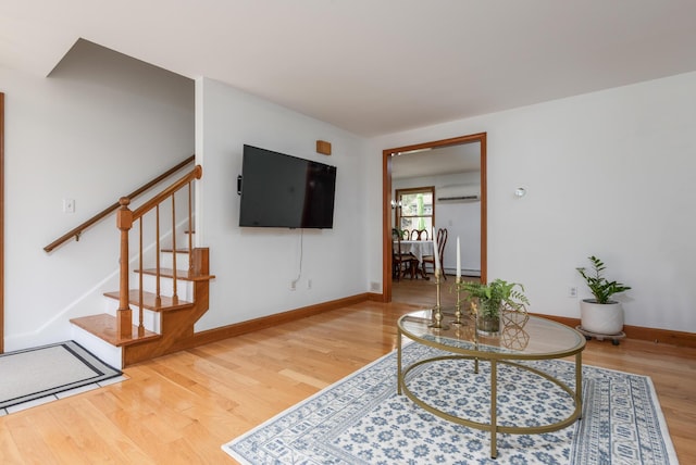 784 Ocean Ave, Portland, ME 04103 - living area with wood finished floors, stairs, baseboards, and a wall mounted air conditioner