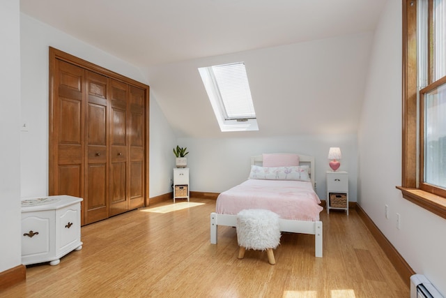 784 Ocean Ave, Portland, ME 04103 - bedroom with a baseboard heating unit, a skylight, light wood-style flooring, lofted ceiling, and multiple windows