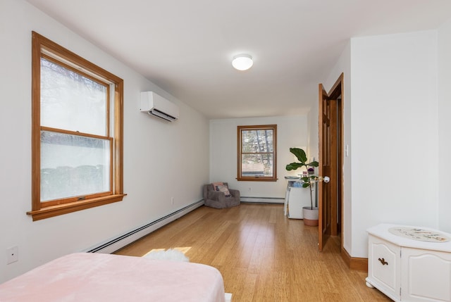 784 Ocean Ave, Portland, ME 04103 - bedroom featuring baseboard heating, a wall mounted air conditioner, light wood-style floors, and a baseboard heating unit