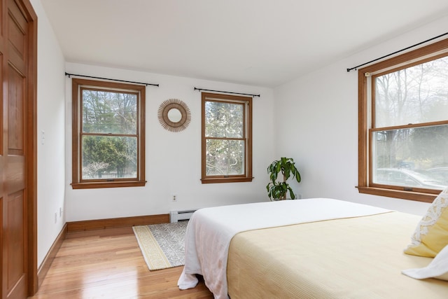784 Ocean Ave, Portland, ME 04103 - bedroom with light wood finished floors, a baseboard heating unit, multiple windows, and baseboards