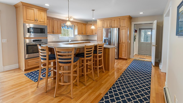 74 Town Farm Rd, Hampden, ME 04444 - kitchen featuring stainless steel appliances, baseboard heating, light wood finished floors, a center island, and hanging light fixtures