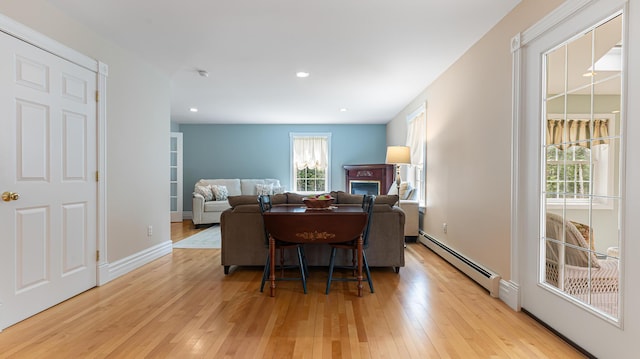 74 Town Farm Rd, Hampden, ME 04444 - dining room with baseboard heating, light wood-style flooring, a glass covered fireplace, recessed lighting, and baseboards