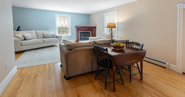 74 Town Farm Rd, Hampden, ME 04444 - living area with light wood-style floors, baseboard heating, a glass covered fireplace, baseboards, and recessed lighting