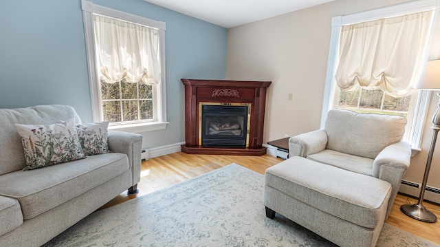 74 Town Farm Rd, Hampden, ME 04444 - living area featuring wood finished floors, a glass covered fireplace, a baseboard heating unit, and baseboards