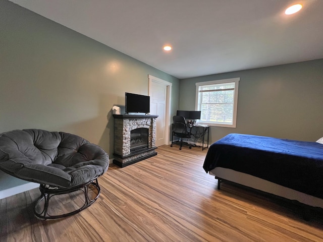 99 St John Rd, Fort Kent, ME 04743 - bedroom with wood finished floors, a stone fireplace, and recessed lighting