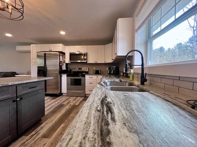 99 St John Rd, Fort Kent, ME 04743 - kitchen featuring wood finished floors, a sink, stainless steel appliances, white cabinetry, and light stone counters