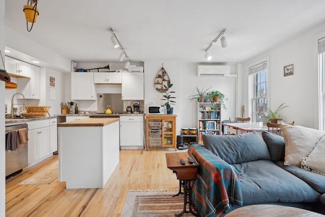 17 Pine St Unit 3, Portland, ME 04102 - kitchen with a sink, stainless steel dishwasher, rail lighting, a wall unit AC, and open floor plan