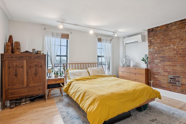 17 Pine St Unit 3, Portland, ME 04102 - bedroom featuring a wall unit AC, light wood finished floors, multiple windows, and rail lighting