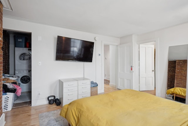 17 Pine St Unit 3, Portland, ME 04102 - bedroom featuring stacked washer / drying machine, light wood finished floors, and brick wall