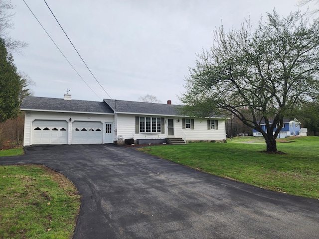 ranch-style home with a front lawn, a chimney, aphalt driveway, and an attached garage