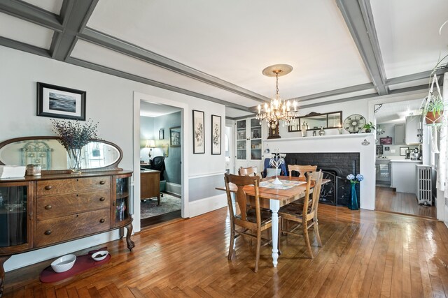 98 Main St, Winthrop, ME 04364 - dining space with a chandelier, coffered ceiling, a fireplace, beamed ceiling, and baseboards