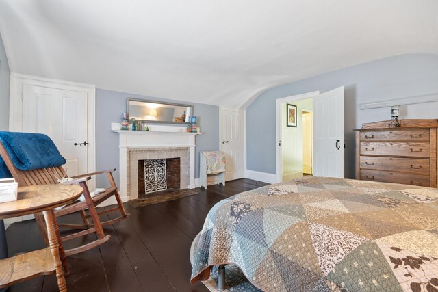 98 Main St, Winthrop, ME 04364 - bedroom with lofted ceiling, hardwood / wood-style floors, baseboards, and a tiled fireplace