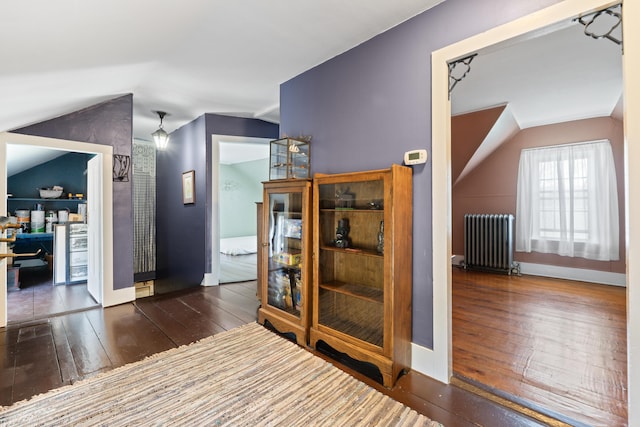 98 Main St, Winthrop, ME 04364 - corridor featuring radiator heating unit, vaulted ceiling, wood-type flooring, and baseboards