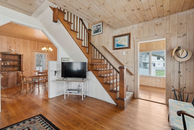 60 Grove St, Wells, ME 04090 - living area with stairs, wooden ceiling, a chandelier, wooden walls, and wood-type flooring