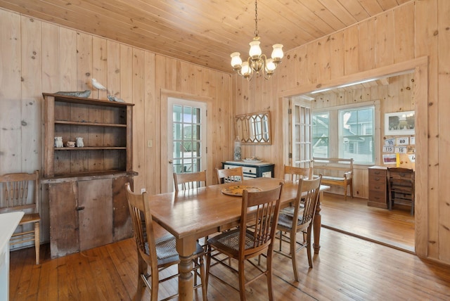60 Grove St, Wells, ME 04090 - dining area featuring light wood-style floors, wood walls, an inviting chandelier, and wood ceiling