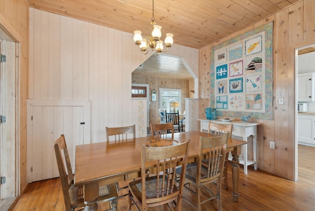 60 Grove St, Wells, ME 04090 - dining area with an inviting chandelier, wood ceiling, arched walkways, light wood-style floors, and wooden walls