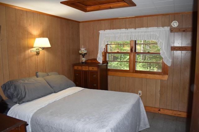 bedroom featuring wood walls and attic access