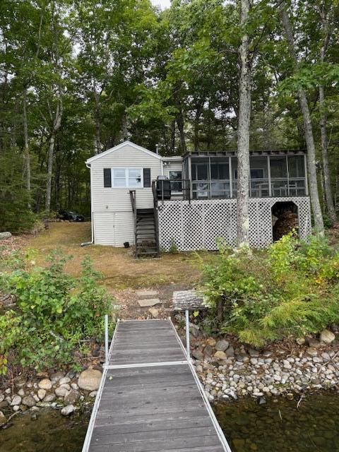 back of property featuring stairway and a sunroom