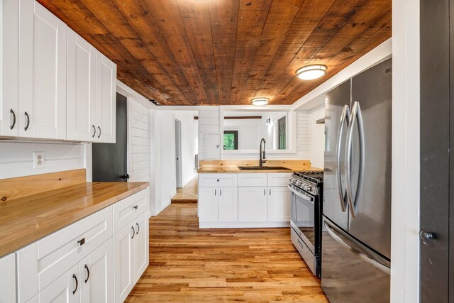 108 Sandy Beach Rd Unit 71, Glenburn, ME 04401 - kitchen with appliances with stainless steel finishes, wood counters, wood ceiling, light wood-style flooring, and white cabinetry