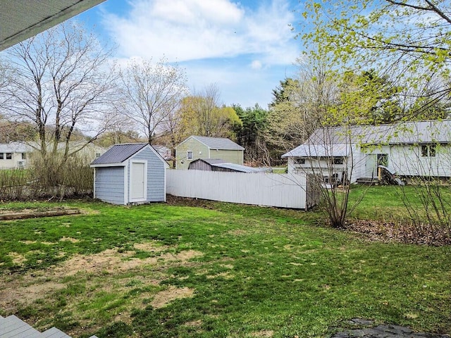 view of yard featuring an outdoor structure, a shed, and fence