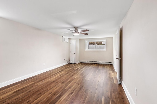 spare room featuring ceiling fan, baseboards, dark wood-style floors, and a baseboard heating unit