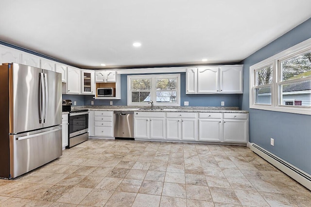 kitchen featuring baseboard heating, stainless steel appliances, a sink, and a wealth of natural light