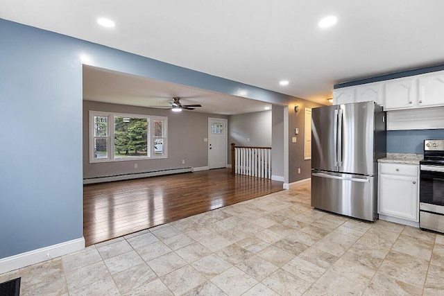 kitchen featuring baseboards, a baseboard radiator, stainless steel appliances, and white cabinets