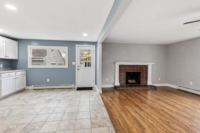 unfurnished living room featuring recessed lighting, a brick fireplace, a ceiling fan, baseboard heating, and baseboards