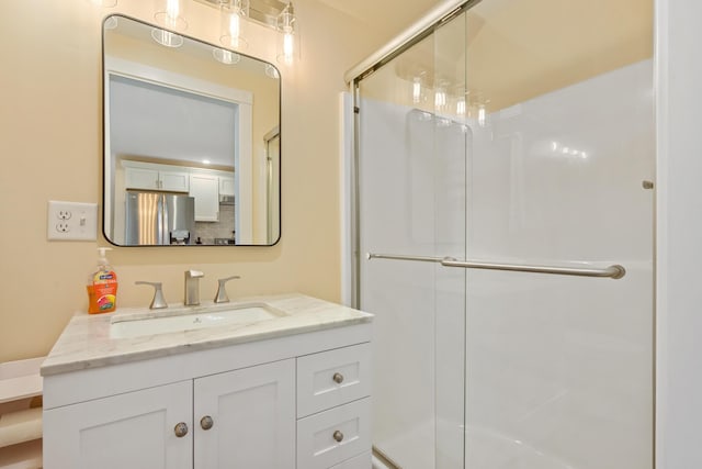 bathroom with a shower stall and vanity