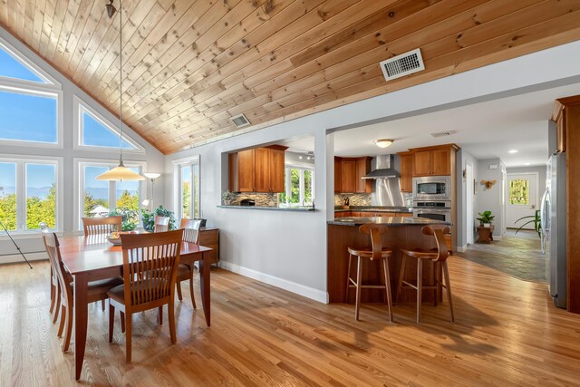 48 White Mountain Way, Bridgton, ME 04009 - dining space with light wood-style floors, baseboards, wood ceiling, and high vaulted ceiling