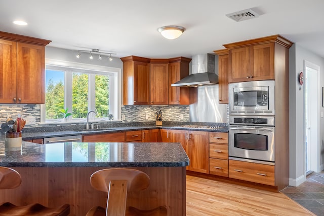 48 White Mountain Way, Bridgton, ME 04009 - kitchen featuring stainless steel appliances, wall chimney exhaust hood, a sink, and a breakfast bar area