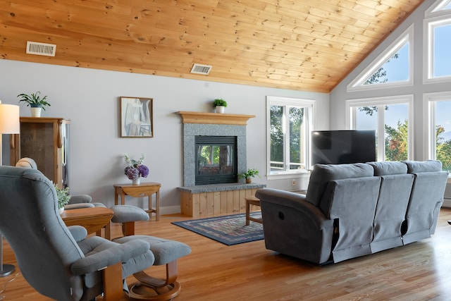 48 White Mountain Way, Bridgton, ME 04009 - living area featuring wooden ceiling, light wood-style flooring, a tiled fireplace, high vaulted ceiling, and baseboards