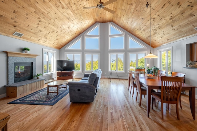 48 White Mountain Way, Bridgton, ME 04009 - living area featuring a baseboard heating unit, high vaulted ceiling, a tile fireplace, healthy amount of natural light, and a ceiling fan