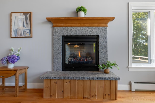 48 White Mountain Way, Bridgton, ME 04009 - detailed view of baseboard heating, baseboards, wood finished floors, and a premium fireplace