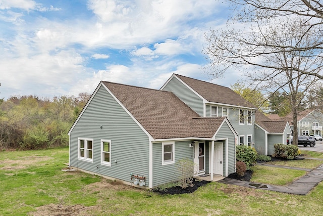 exterior space with a lawn and roof with shingles