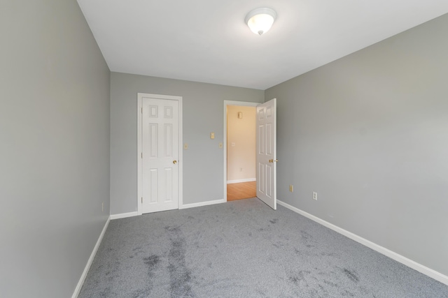 unfurnished bedroom featuring baseboards and carpet flooring