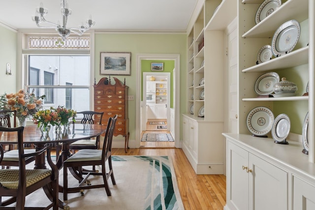 94 Neal St Unit 2N, Portland, ME 04102 - dining area featuring crown molding, a chandelier, and light wood-style flooring