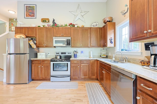 8 Codys Way, Bridgton, ME 04009 - kitchen featuring stainless steel appliances, a sink, brown cabinets, and light wood-style flooring