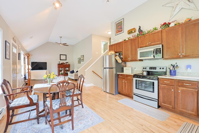 8 Codys Way, Bridgton, ME 04009 - kitchen with appliances with stainless steel finishes, brown cabinetry, vaulted ceiling, light countertops, and light wood-style floors