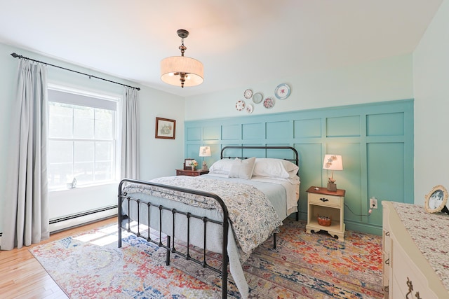 8 Codys Way, Bridgton, ME 04009 - bedroom with baseboard heating, light wood-style flooring, and a decorative wall