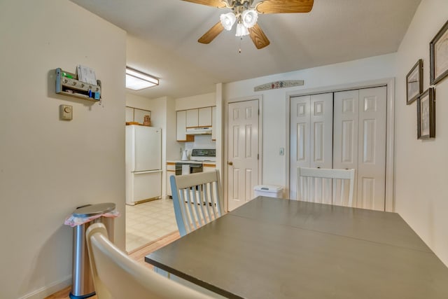 unfurnished dining area featuring a ceiling fan and light floors