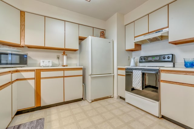 kitchen featuring white appliances, under cabinet range hood, light countertops, and light floors