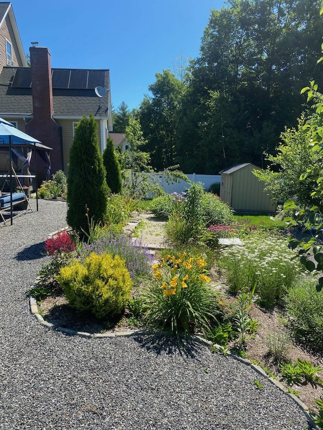 view of yard featuring a gazebo, an outbuilding, a storage shed, and fence