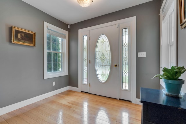 foyer entrance featuring light wood finished floors and baseboards