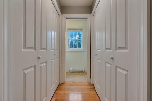 hall with a baseboard heating unit and light wood-style floors