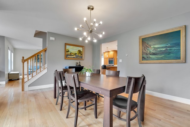 dining space with a chandelier, light wood finished floors, stairway, and baseboards