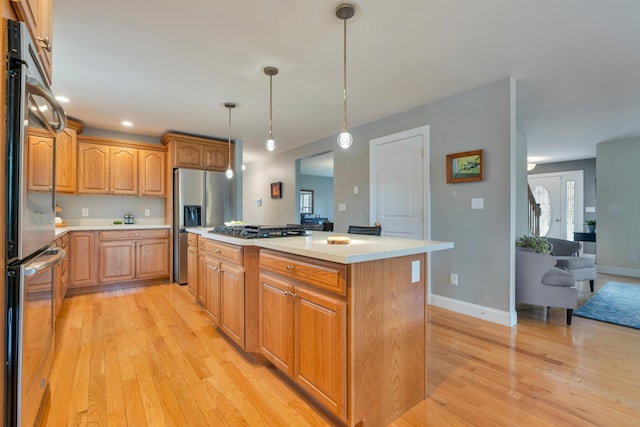 kitchen with light wood-style flooring, stainless steel appliances, and light countertops